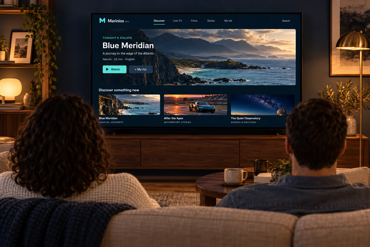 Two people relaxing on a sofa in front of a television showing Marinios IPTV.